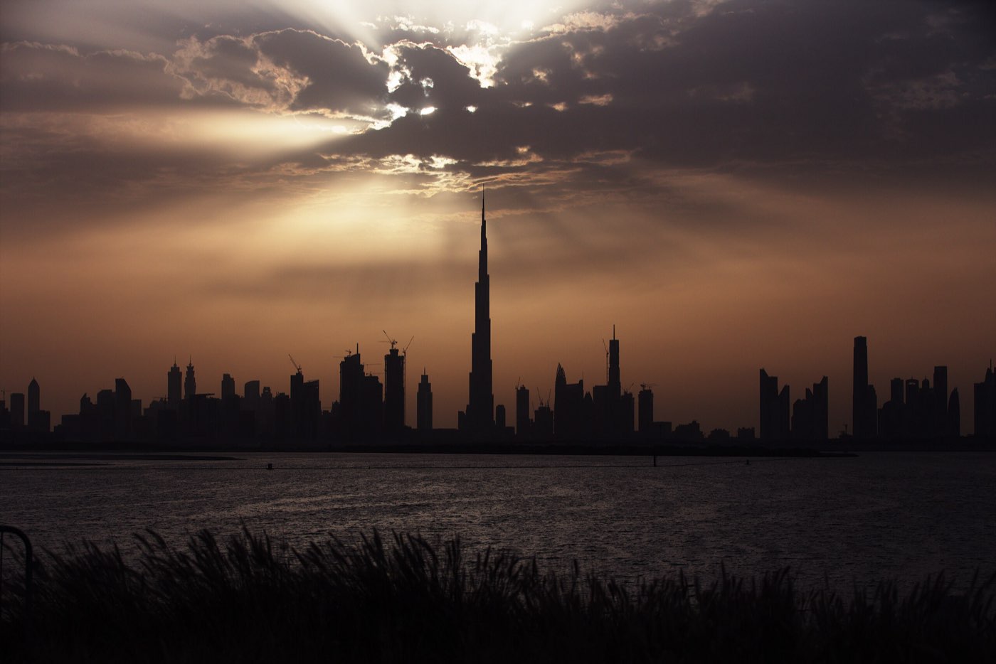 Dubai skyline silhouetted at sunset with the Burj Khalifa